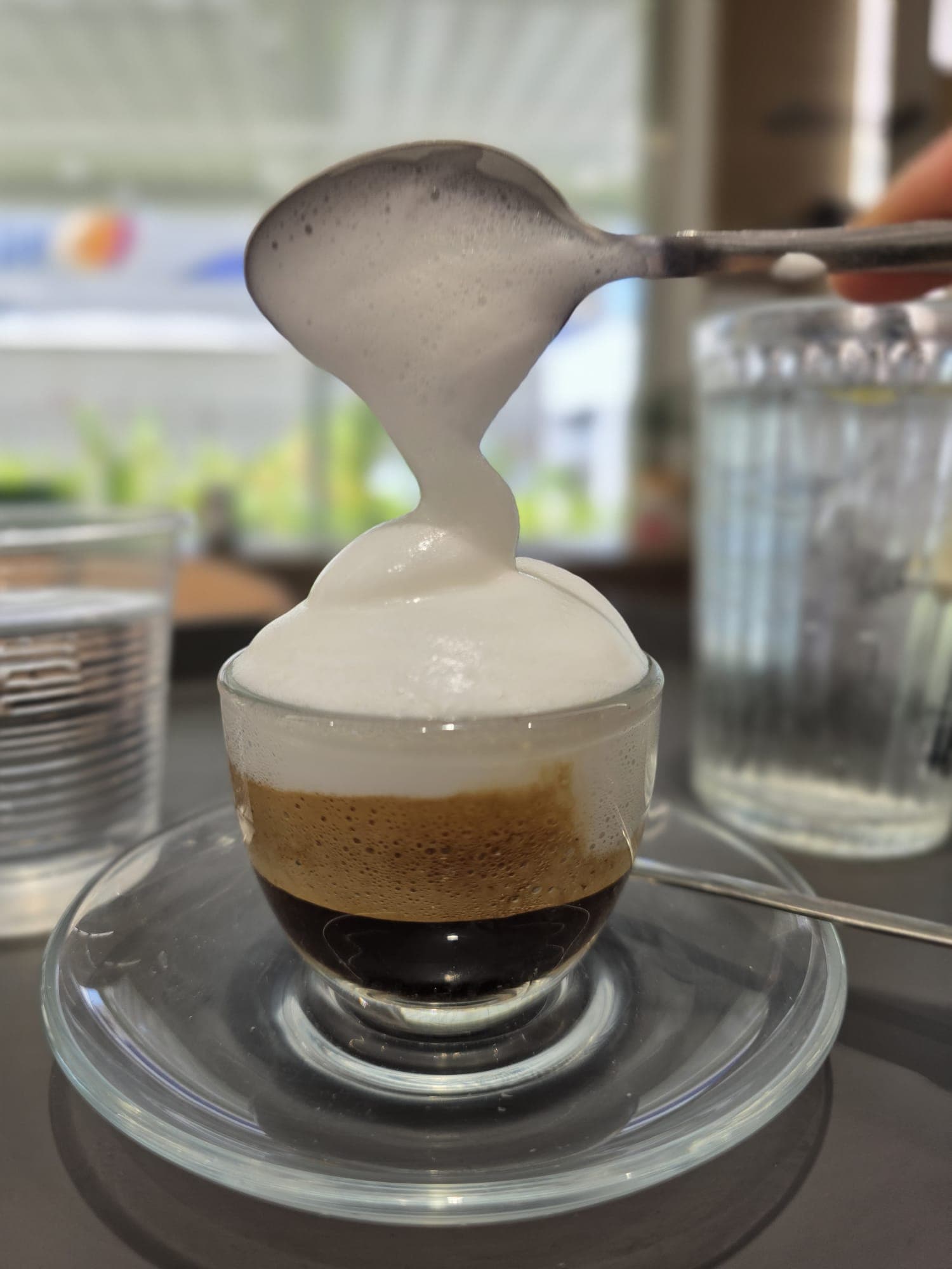 Schiuma di latte versata su caffè espresso
